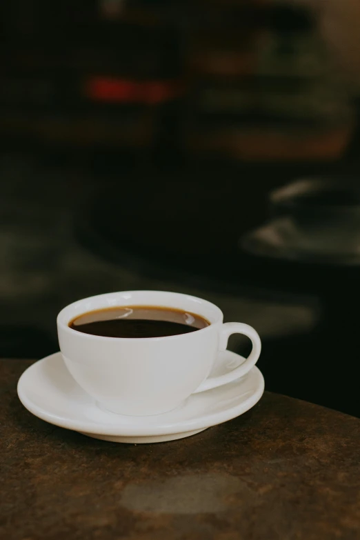 a white coffee cup is sitting on top of a table