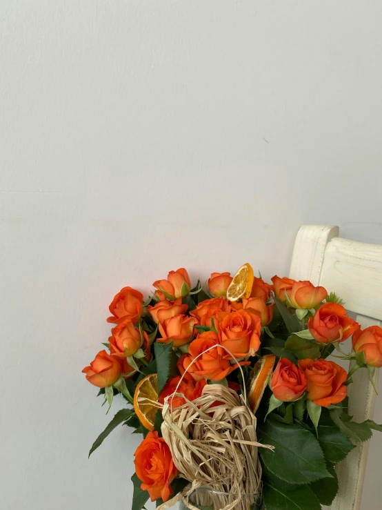 a white chair with orange flowers and an orange slice sitting on top of it