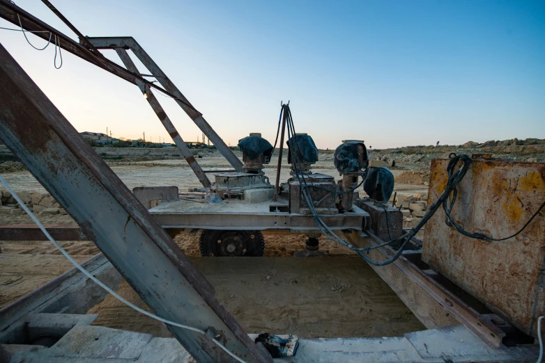 a broken and rusty structure sitting in a desert landscape