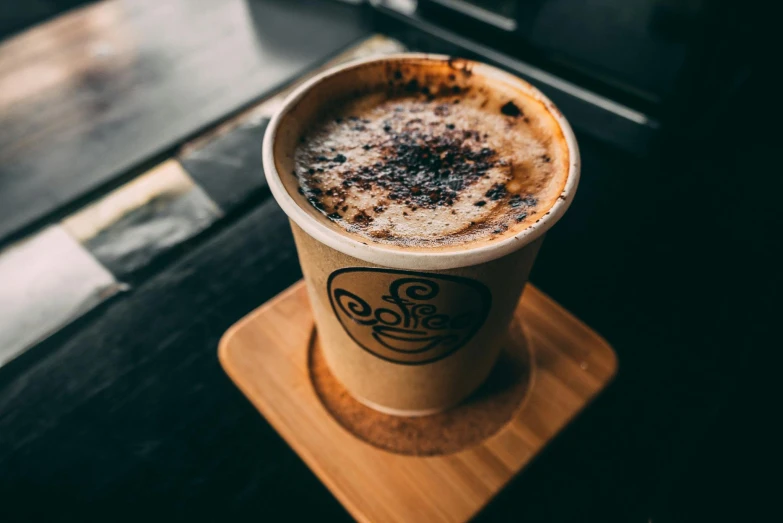 a close up of a foamy drink on a coaster