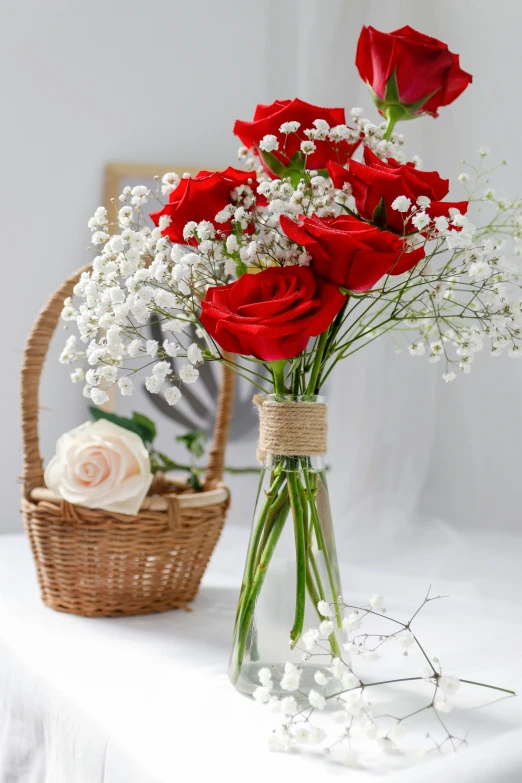 roses and babies breath are arranged in a clear vase