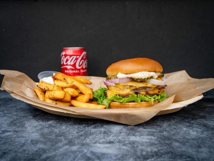 hamburger and french fries with soda sit on the table