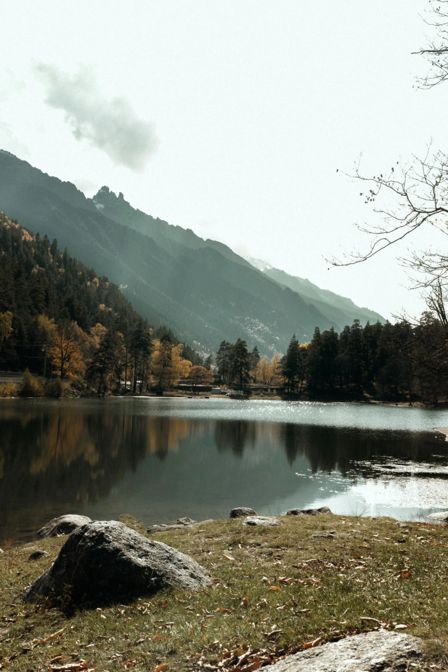 a lake surrounded by mountains on a cloudy day