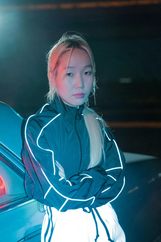 a young woman leaning against a car with her hands on her chest