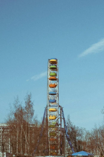 a ferris wheel sits empty as a park rides