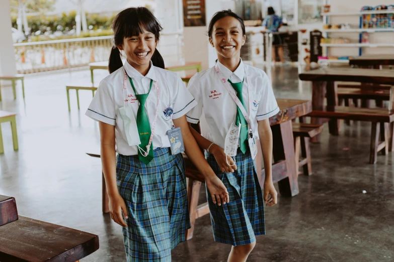 the two girls are dressed in plaid skirts and ties