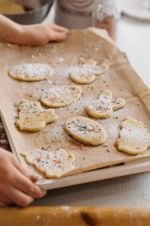 a wooden tray with decorated cookies sitting on top of a wooden table