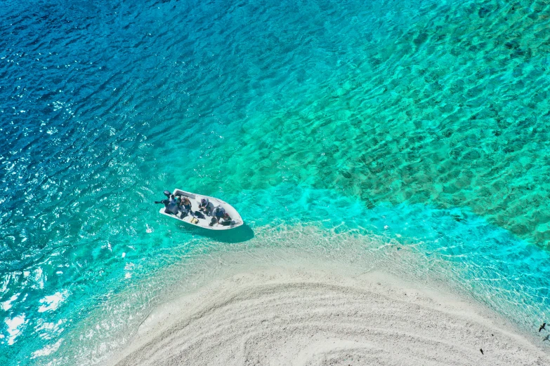 two people in a small boat are near a deserted beach