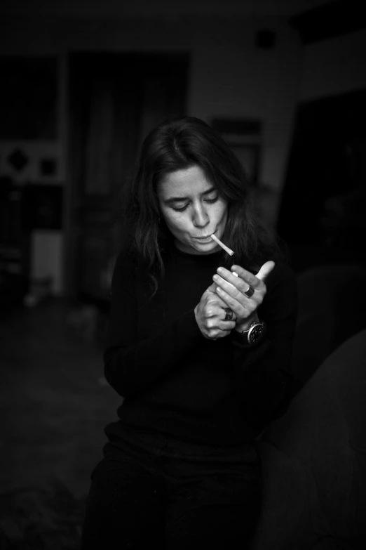 a woman smoking a cigarette in the dark