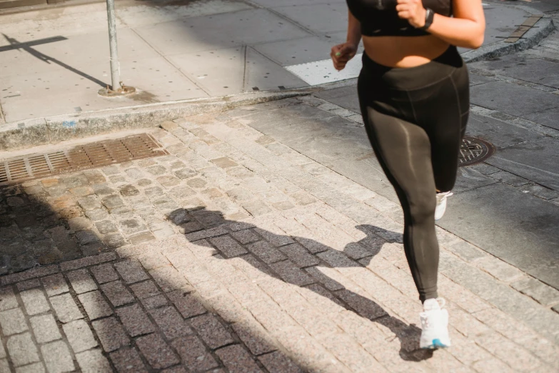 a woman runs on brick streets with her shadow