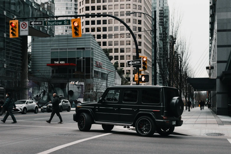 a black suv is stopped at an intersection