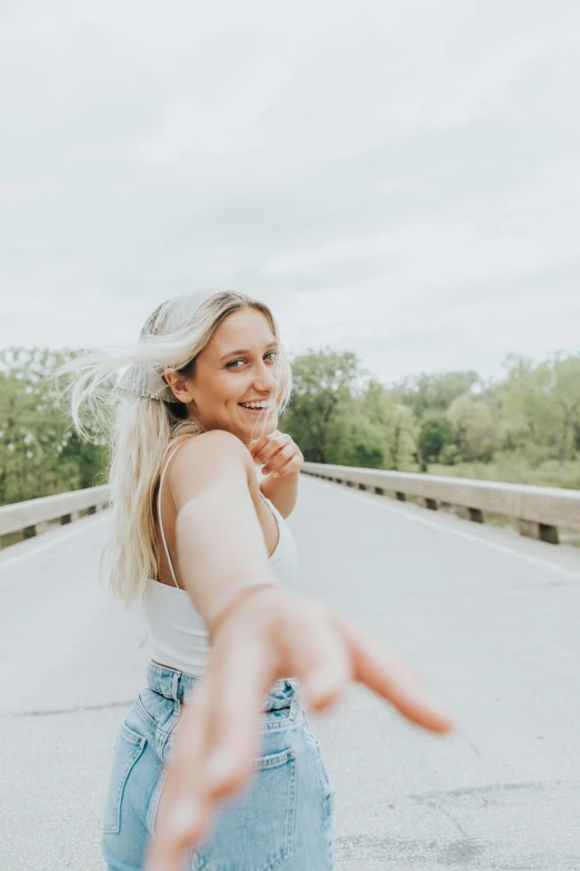 a woman smiles while pointing her finger at someone