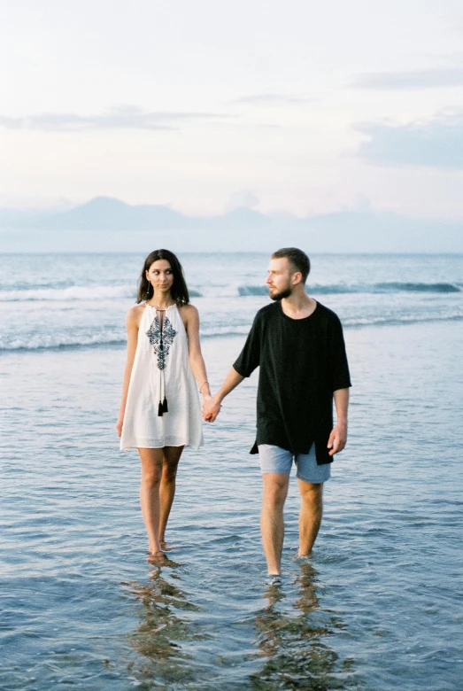 a couple holding hands walking on the beach