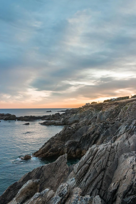 the ocean with a person on the cliff watching the sky