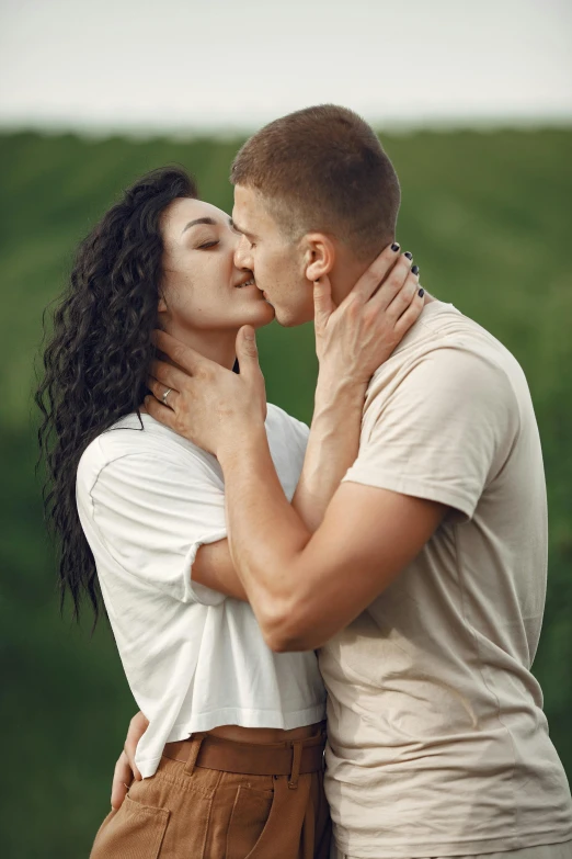 a man and woman sharing a kiss outdoors