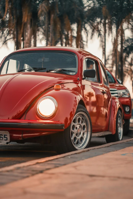 a red bug sitting in the middle of a parking space