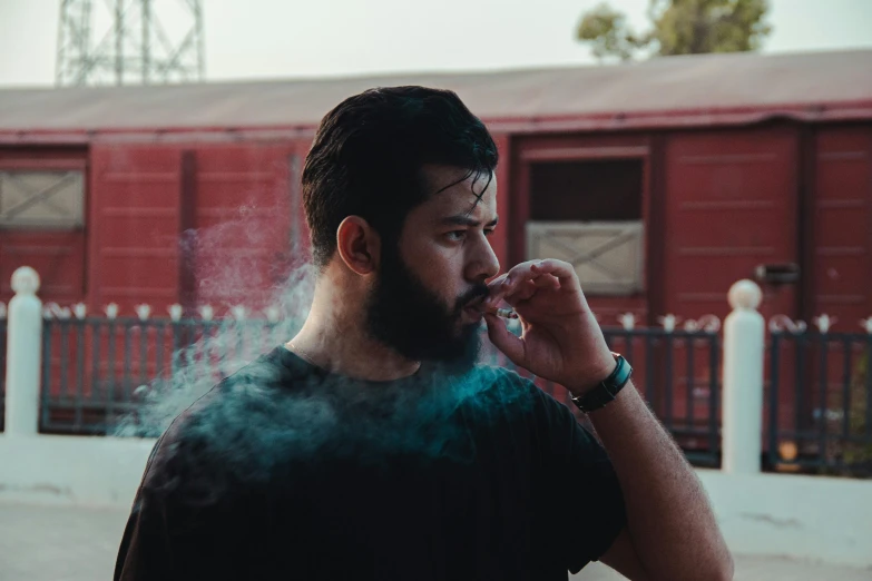 a man smoking soing near a red building