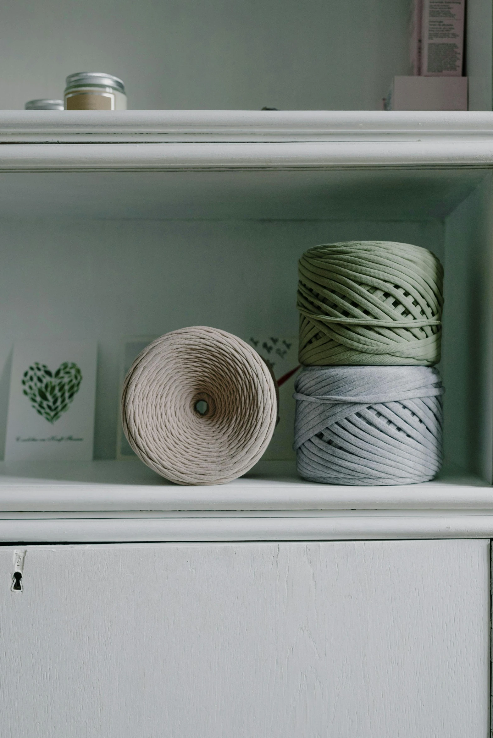 yarn and other things are sitting on top of shelves