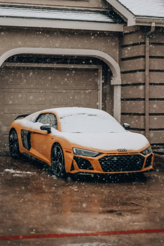 a yellow sports car is covered in snow