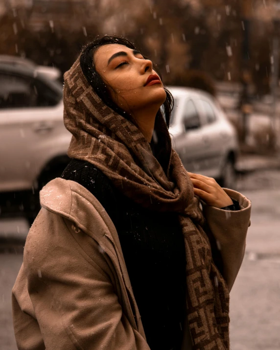 woman looking up to the rain on a street