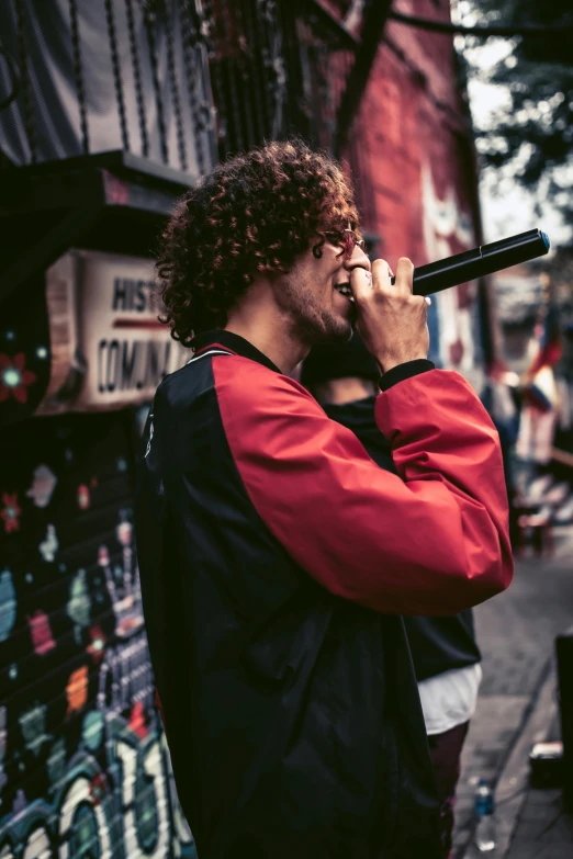 a man stands on the side walk talking on his phone