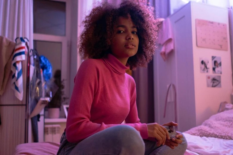 a young woman with pink hair sitting on her bed