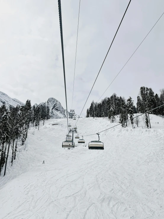 a person riding a ski lift up a snowy mountain