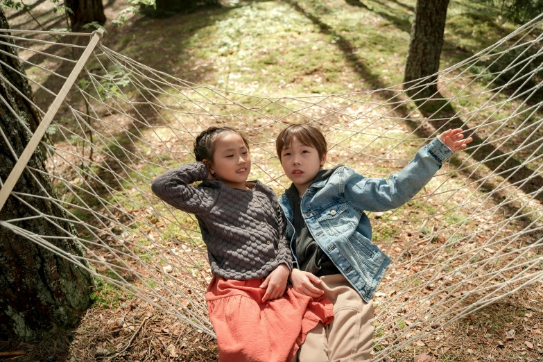 two s sit in a hammock on the side of a trail