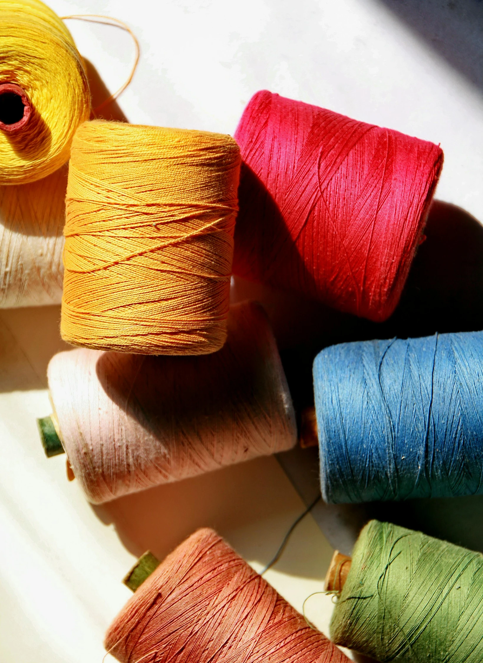 a bunch of colorful spools of thread sitting on top of each other