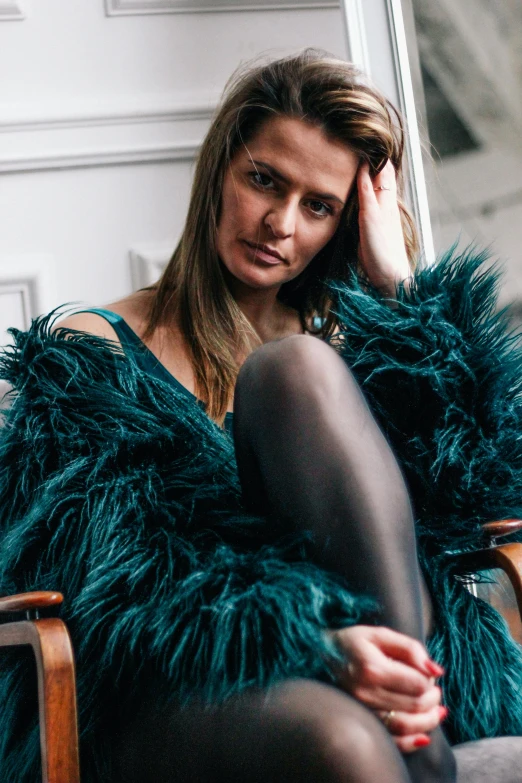 a woman with dark stockings and black stockings sits in a chair