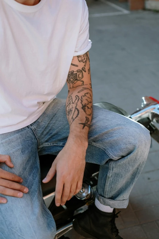 a person with a tattoo on their arm riding a skateboard