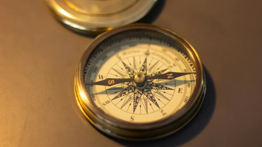 a small compass is placed next to the lid