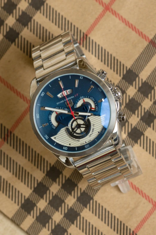 a stainless steel chronog watch on a checkered table