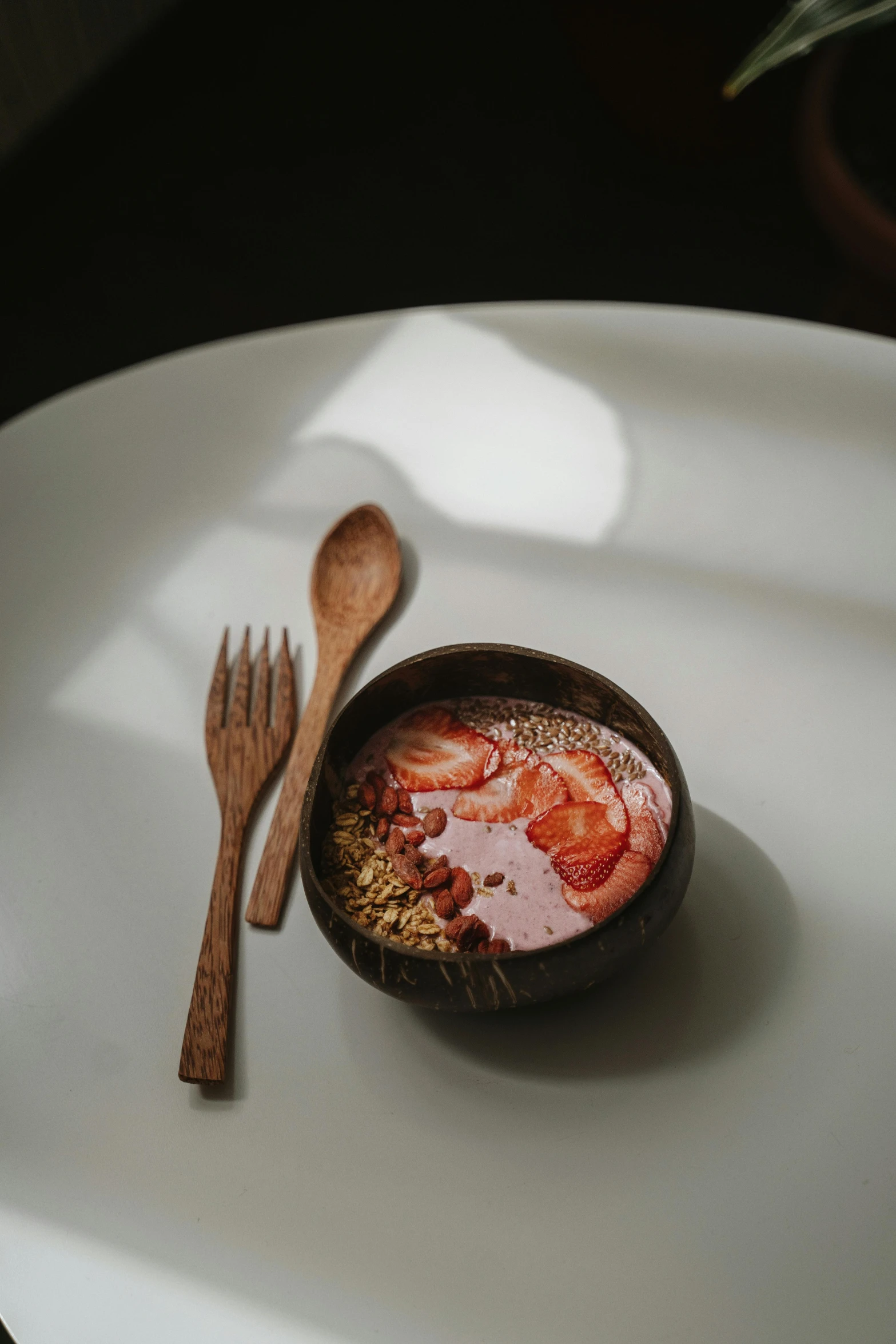 a small bowl with oatmeal and a wooden spoon on a white plate