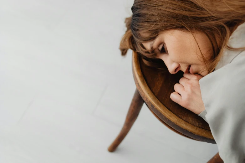 a woman with long hair resting her head on her hand