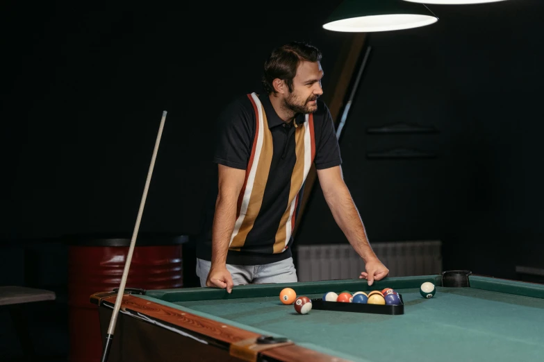 man playing a game of pool in his apartment