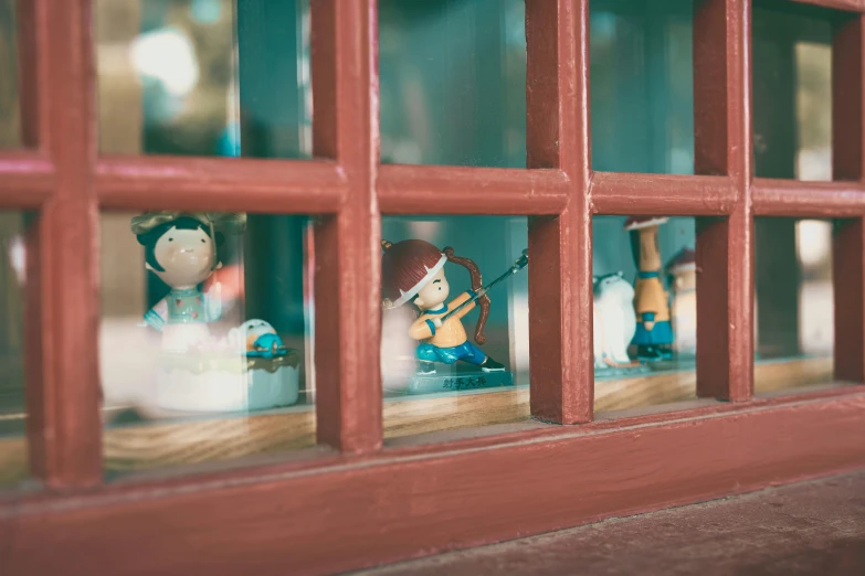 some little figurines are sitting behind a window