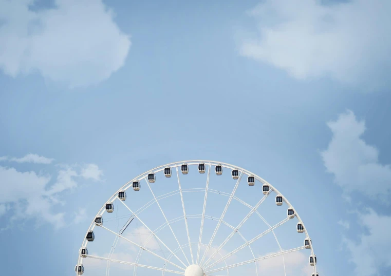 the giant wheel is lit up on the sunny day