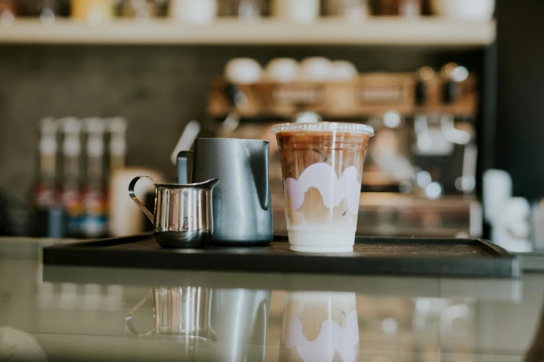 two cups with iced beverages sitting on a bar