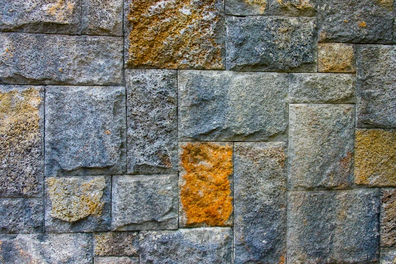 a rock wall with small yellow squares embedded