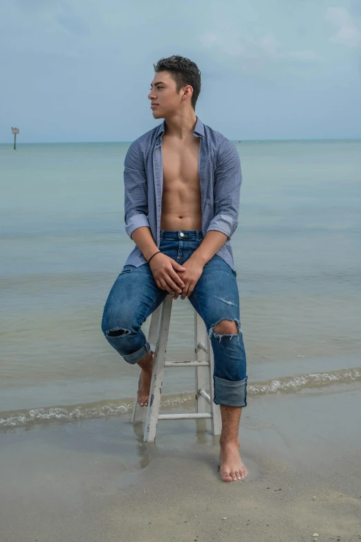 young man sitting on a ladder at the beach