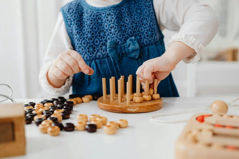 a young child at a table playing with wooden pegs