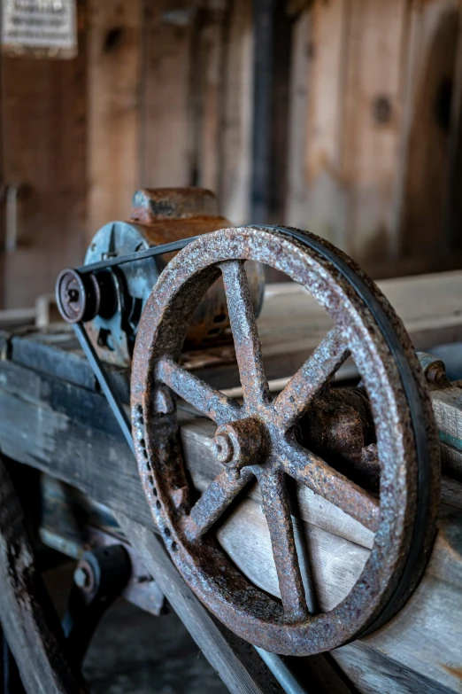 a rusty wheel of some sort is sitting on some pieces of wood