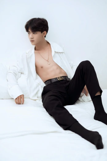 a man in a shirt and pants laying on a bed