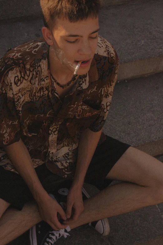 a boy with an object in his mouth sitting on the steps