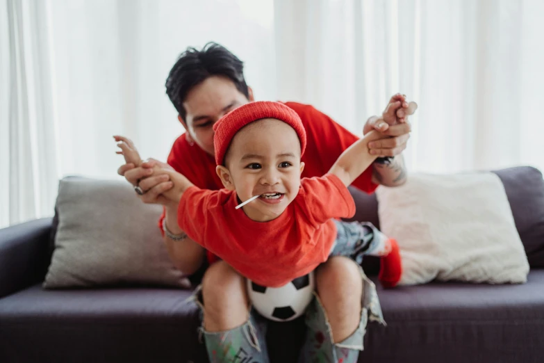 man and his daughter are playing with the ball