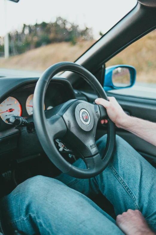 a person sitting in their car holding the steering wheel