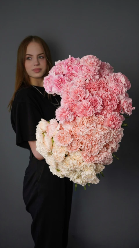 a woman holding out pink and white flowers