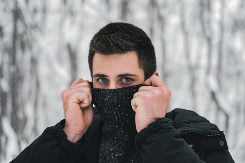 a man holding a knitted head wrap over his mouth