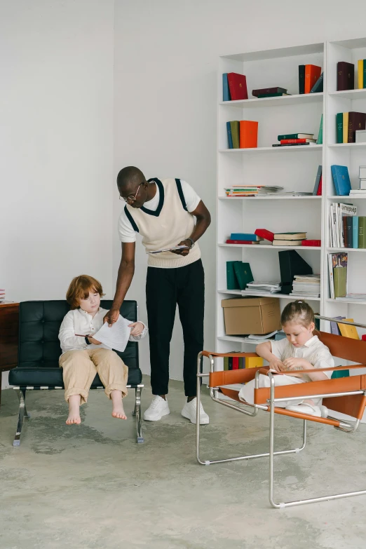 two women and two children in a room with a book shelf